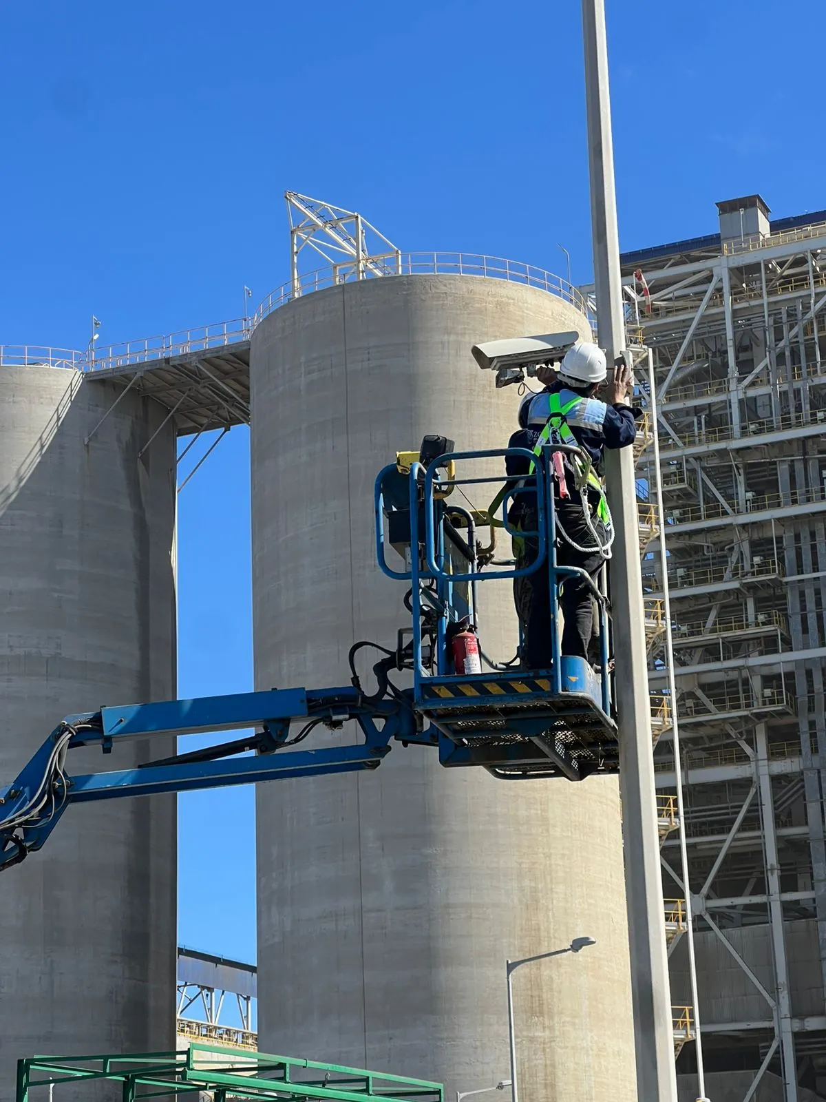 Équipe de techniciens et ingénieurs réalisant une installation de système de sécurité sur site, illustrant l'expertise terrain, le câblage réseau et la mise en place de caméras et équipements techniques avec précision.